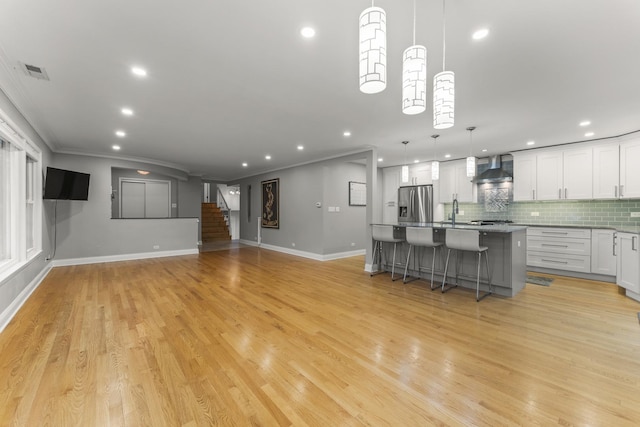 3257 N Nottingham Ave, Chicago, IL 60634 - kitchen featuring stainless steel fridge, recessed lighting, a kitchen island with sink, wall chimney range hood, and tasteful backsplash