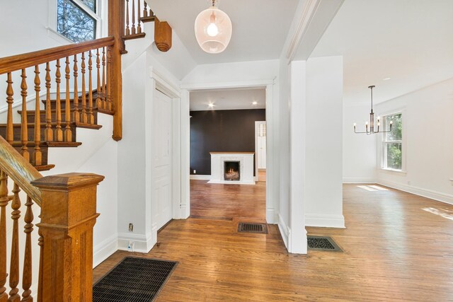 1123 Linden Ave, Wilmette, IL 60091 - entryway with hardwood / wood-style flooring, a fireplace with flush hearth, a chandelier, and stairs