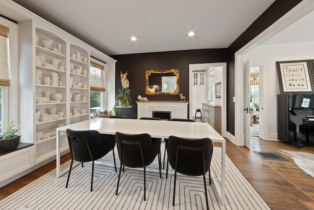 1123 Linden Ave, Wilmette, IL 60091 - kitchen with dark wood-style flooring, a fireplace, recessed lighting, a breakfast bar, and light countertops