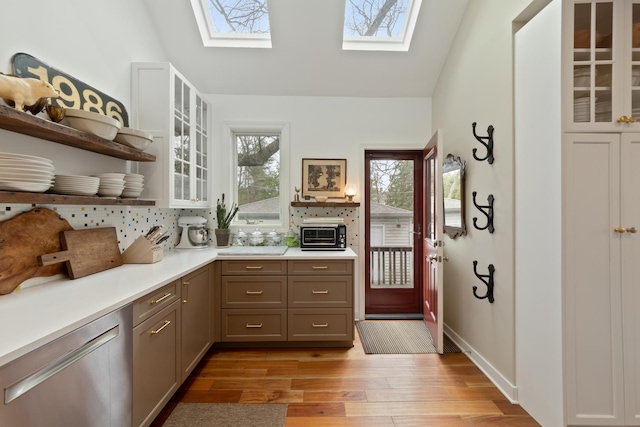 1123 Linden Ave, Wilmette, IL 60091 - kitchen featuring a skylight, open shelves, stainless steel dishwasher, light wood-style floors, and light countertops