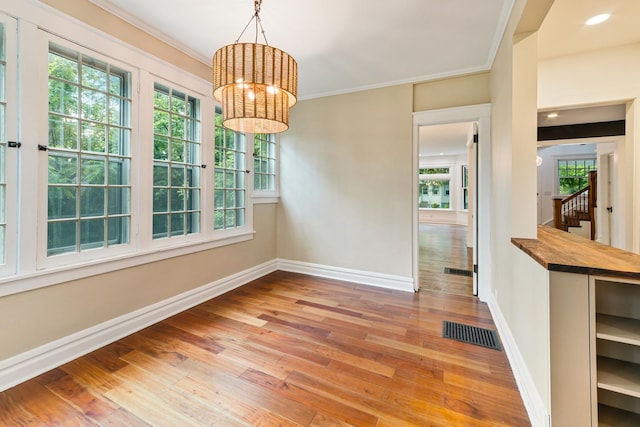 1123 Linden Ave, Wilmette, IL 60091 - unfurnished dining area with a chandelier, wood-type flooring, stairs, and ornamental molding