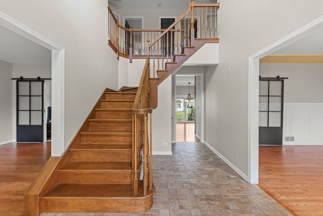 24006 Skyler Ln, Plainfield, IL 60586 - stairway featuring a barn door, a towering ceiling, and stone finish flooring