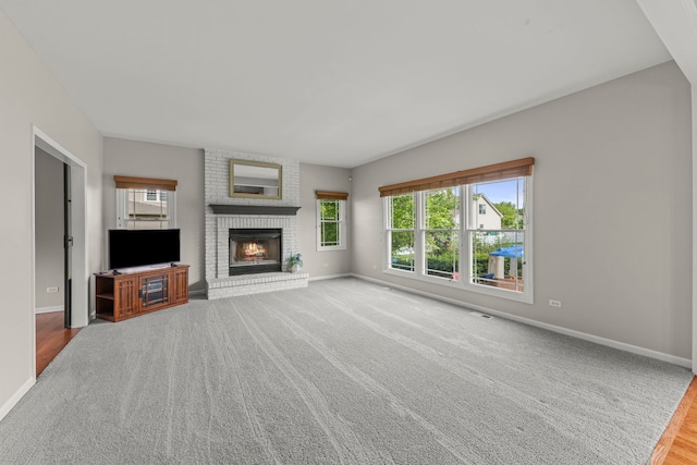 24006 Skyler Ln, Plainfield, IL 60586 - unfurnished living room with plenty of natural light, a brick fireplace, and carpet