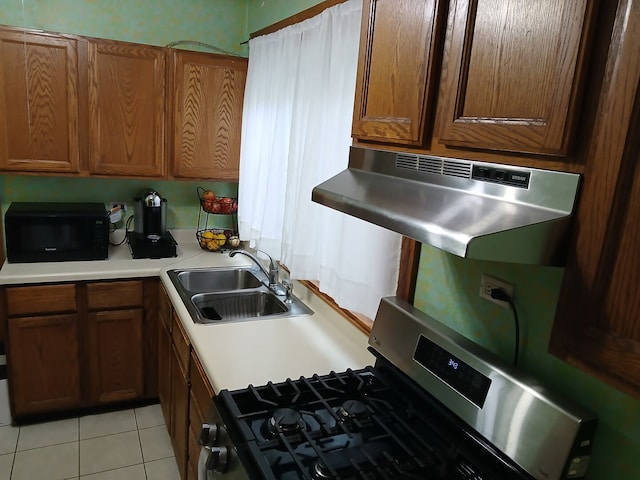 4936 S Karlov Ave, Chicago, IL 60632 - kitchen featuring gas stove, black microwave, under cabinet range hood, light tile patterned floors, and light countertops
