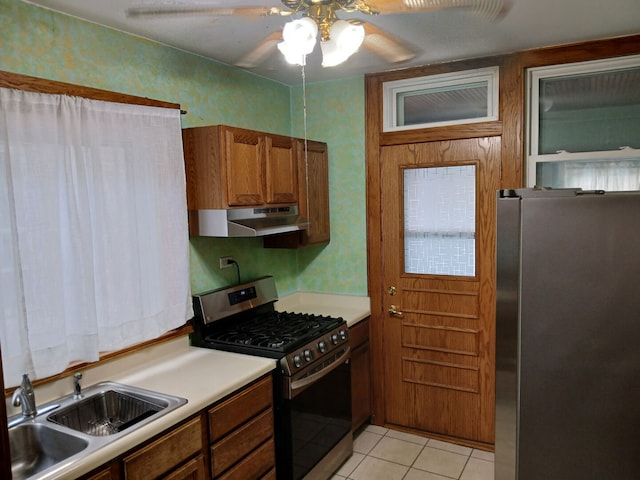 4936 S Karlov Ave, Chicago, IL 60632 - kitchen with stainless steel appliances, under cabinet range hood, brown cabinetry, ceiling fan, and light countertops