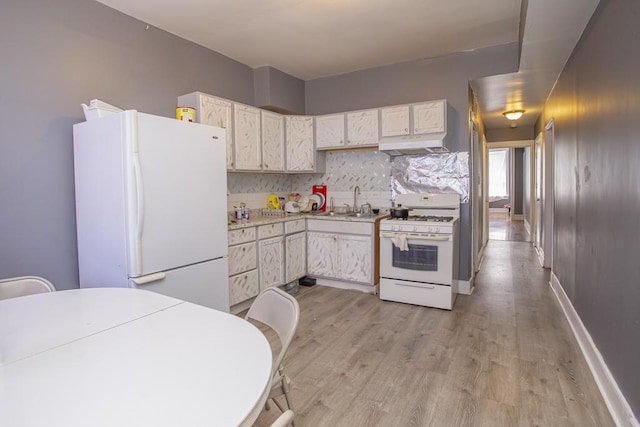 3810 W Ohio St, Chicago, IL 60624 - kitchen featuring white appliances, light wood-style floors, under cabinet range hood, light countertops, and tasteful backsplash