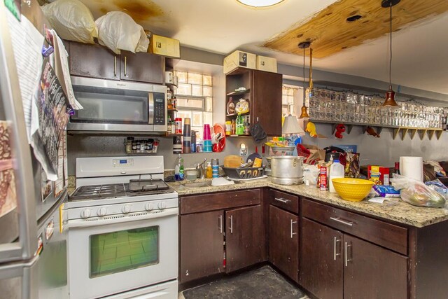 3810 W Ohio St, Chicago, IL 60624 - kitchen with white gas range oven, stainless steel microwave, open shelves, and dark brown cabinetry