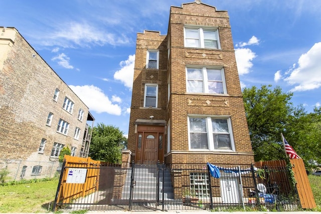 3810 W Ohio St, Chicago, IL 60624 - view of front of property featuring brick siding, a fenced front yard, and a gate