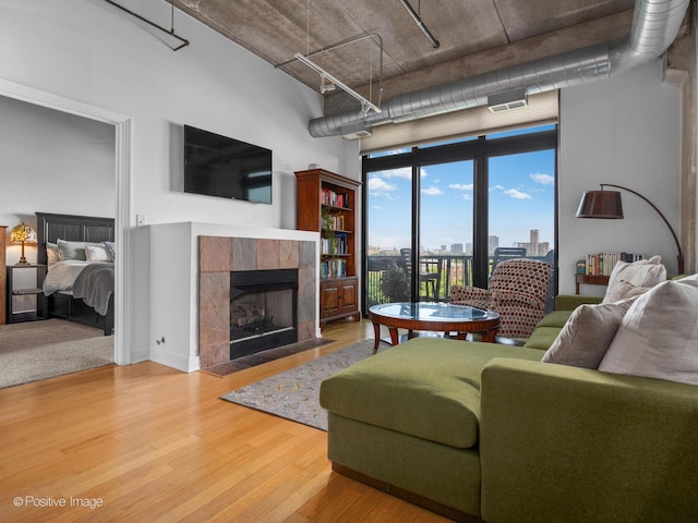 833 W 15th Pl Unit 502, Chicago, IL 60608 - living room with a tiled fireplace, wood finished floors, and a high ceiling
