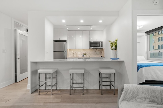 88 W Schiller St Unit 904, Chicago, IL 60610 - kitchen featuring stainless steel appliances, modern cabinets, white cabinets, and a breakfast bar