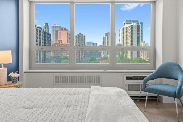 88 W Schiller St Unit 904, Chicago, IL 60610 - bedroom featuring a skyline view, wood finished floors, and a wall unit AC