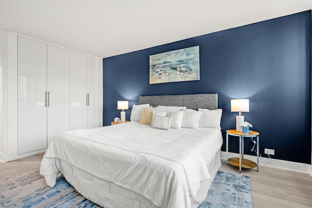 88 W Schiller St Unit 904, Chicago, IL 60610 - bedroom with light wood-type flooring, a closet, and an accent wall