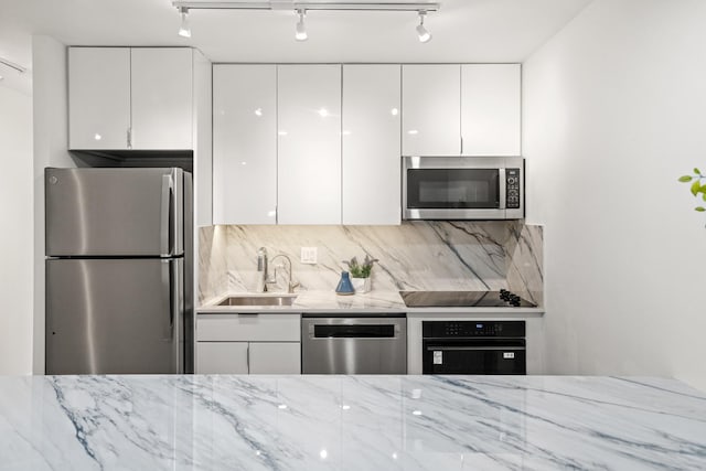 88 W Schiller St Unit 904, Chicago, IL 60610 - kitchen with black appliances, modern cabinets, white cabinets, decorative backsplash, and light stone countertops