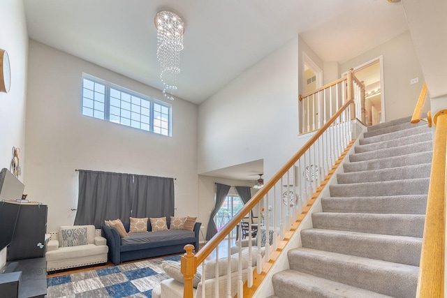 2012 Juniper Ct Unit 2012, Glendale Heights, IL 60139 - living area featuring a towering ceiling, stairs, a chandelier, and a ceiling fan