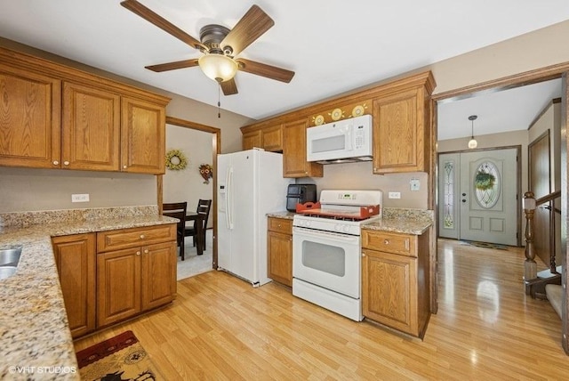 1127 Alpine Ln, Lemont, IL 60439 - kitchen featuring white appliances, light wood-style flooring, brown cabinetry, a ceiling fan, and light stone countertops