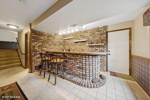 1127 Alpine Ln, Lemont, IL 60439 - indoor dry bar with brick wall, stairway, and tile patterned flooring