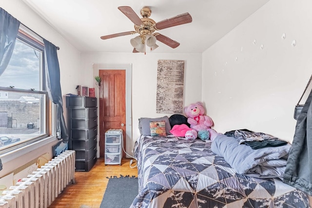 1621 N Central Park Ave, Chicago, IL 60647 - bedroom with radiator heating unit, light wood-style floors, and a ceiling fan