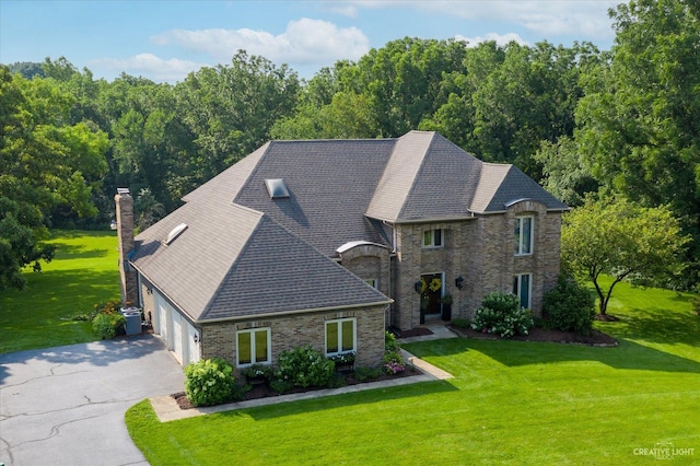 23 Colony Ct, Yorkville, IL 60560 - french country home featuring driveway, a front lawn, a garage, a chimney, and a shingled roof
