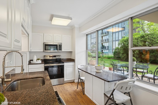 1440 Sheridan Rd Unit 101, Wilmette, IL 60091 - kitchen with appliances with stainless steel finishes, crown molding, white cabinets, and dark stone counters