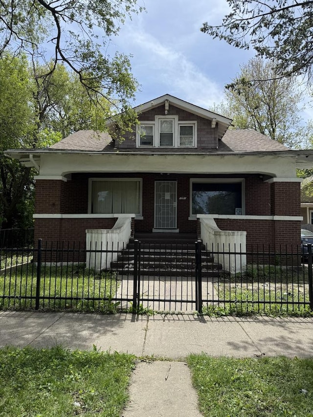 bungalow with brick siding, roof with shingles, a fenced front yard, and a porch