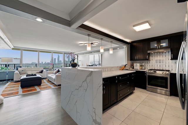 400 E Randolph St Unit 2603, Chicago, IL 60601 - kitchen with stainless steel gas range, open floor plan, light stone counters, decorative backsplash, and under cabinet range hood