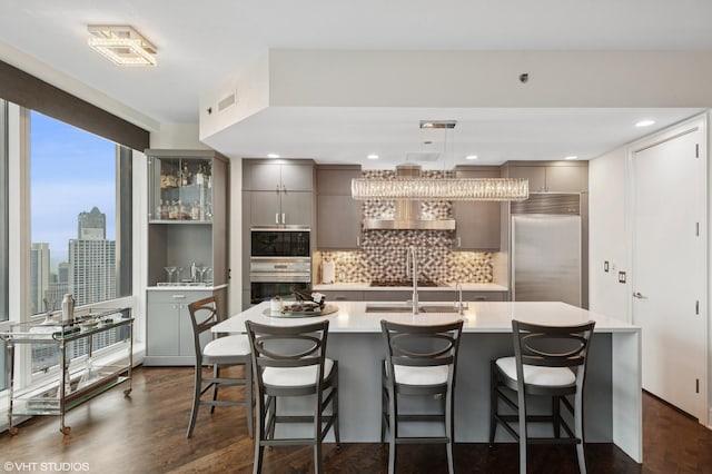 401 N Wabash Ave Unit 44F, Chicago, IL 60611 - kitchen with built in appliances, gray cabinetry, dark wood-style floors, light countertops, and decorative backsplash