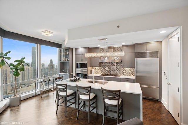 401 N Wabash Ave Unit 44F, Chicago, IL 60611 - kitchen featuring built in appliances, gray cabinets, tasteful backsplash, a kitchen bar, and recessed lighting