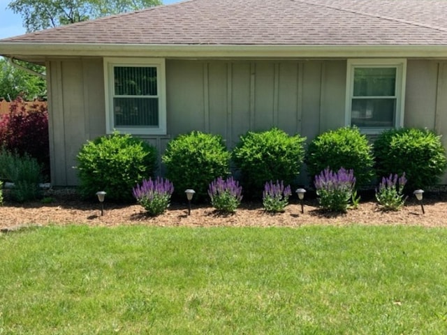 1412 Timberline Dr, Joliet, IL 60431 - view of side of home with board and batten siding, roof with shingles, and a lawn
