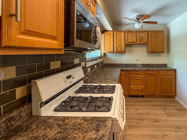 1840 W Hatherleigh Ct Unit 1E, Mount Prospect, IL 60056 - kitchen with stainless steel microwave, white range with gas stovetop, brown cabinets, light wood-type flooring, and dark countertops