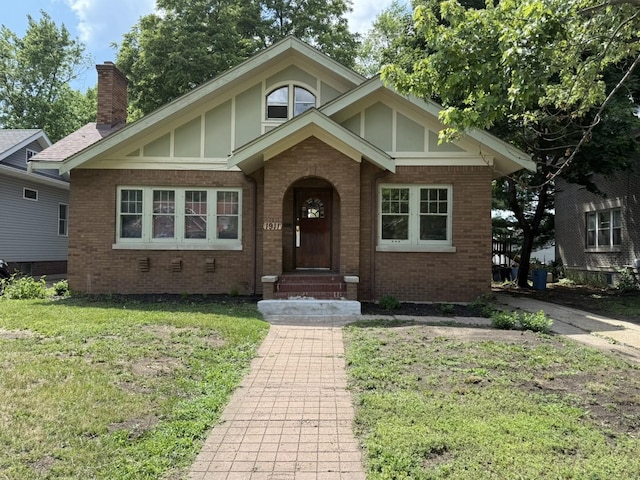 1911 S 4th St, Rockford, IL 61104 - view of front of house featuring brick siding, a front yard, and a chimney