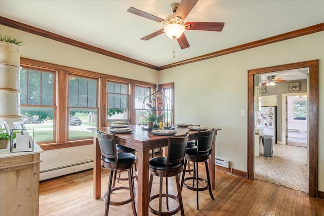 879 2300th Ave, Chestnut, IL 62518 - dining area with a baseboard heating unit, a ceiling fan, light wood finished floors, plenty of natural light, and ornamental molding