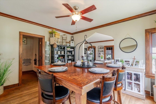 879 2300th Ave, Chestnut, IL 62518 - dining area featuring wood finished floors, a ceiling fan, arched walkways, and ornamental molding