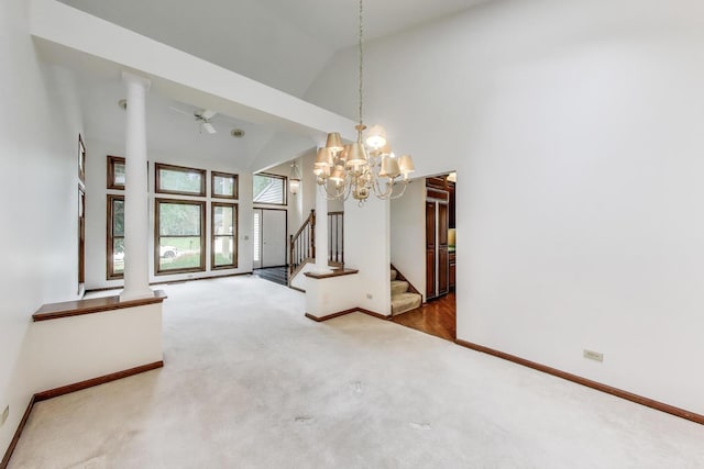 705 Wood Creek Dr, Antioch, IL 60002 - carpeted spare room featuring stairs, a chandelier, high vaulted ceiling, and decorative columns