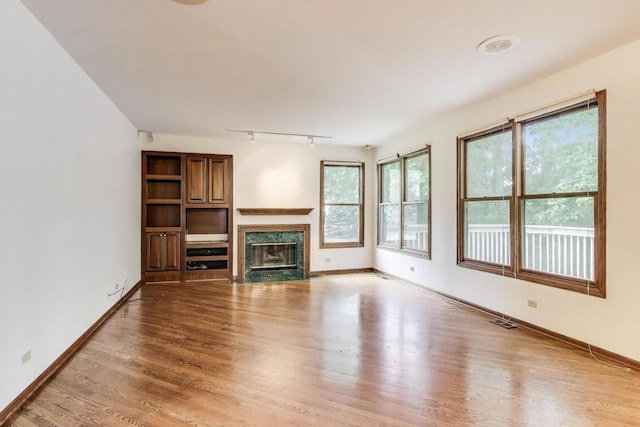 705 Wood Creek Dr, Antioch, IL 60002 - unfurnished living room with light wood-style floors, track lighting, and healthy amount of natural light