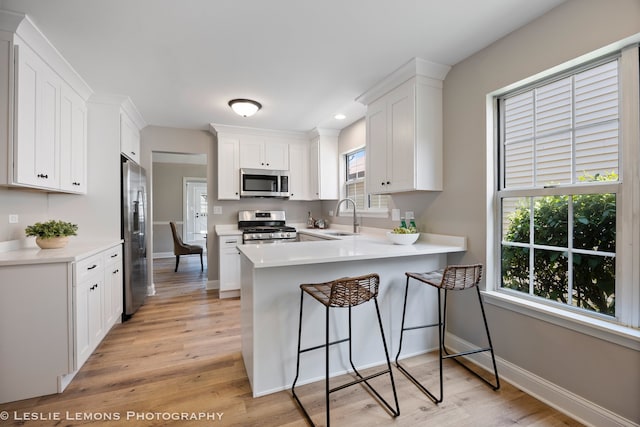 20936 Orange Blossom Ln, Plainfield, IL 60544 - kitchen with stainless steel appliances, a peninsula, light wood-style floors, white cabinets, and recessed lighting