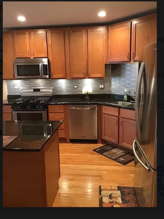 4629 S Langley Ave, Chicago, IL 60653 - kitchen with stainless steel appliances, light wood-style floors, tasteful backsplash, dark stone counters, and recessed lighting