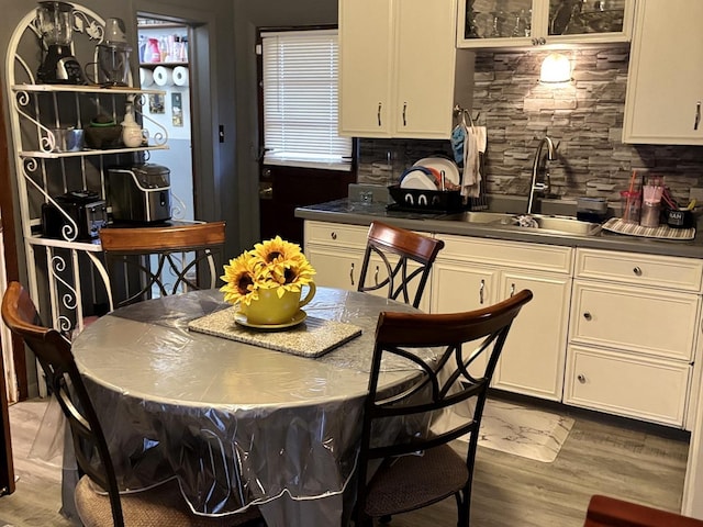 484 Hickory Pl, Elgin, IL 60120 - kitchen featuring dark countertops, decorative backsplash, light wood finished floors, and white cabinetry