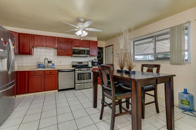 337 E Clark St, Glenwood, IL 60425 - kitchen featuring stainless steel appliances, dark brown cabinets, ceiling fan, stacked washer / dryer, and decorative backsplash