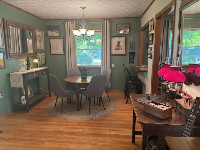 1202 E Van Buren St, Clinton, IL 61727 - dining room with a chandelier, light wood-style flooring, ornamental molding, and a textured ceiling