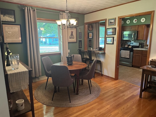 1202 E Van Buren St, Clinton, IL 61727 - dining room featuring a chandelier, healthy amount of natural light, ornamental molding, and light wood-type flooring