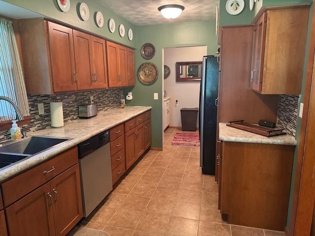 1202 E Van Buren St, Clinton, IL 61727 - kitchen with dishwasher, decorative backsplash, freestanding refrigerator, and light countertops