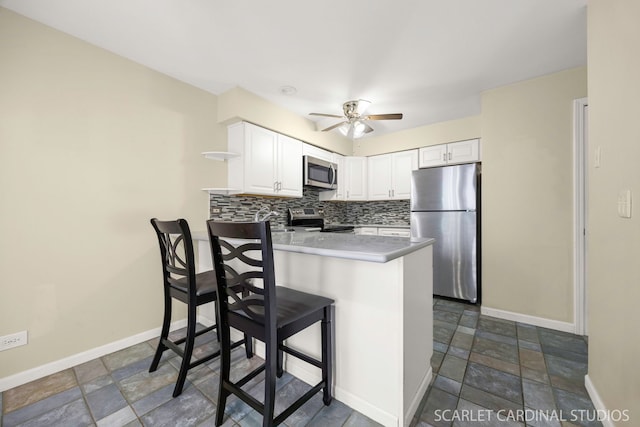 1356 S Lorraine Rd Unit E, Wheaton, IL 60189 - kitchen with stainless steel appliances, a peninsula, stone finish flooring, and a ceiling fan