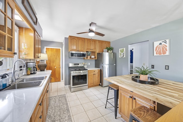 1110 N Main St, Normal, IL 61761 - kitchen with appliances with stainless steel finishes, ceiling fan, glass insert cabinets, light tile patterned floors, and brown cabinetry