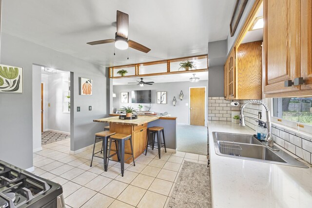 1110 N Main St, Normal, IL 61761 - kitchen with a breakfast bar area, ceiling fan, tasteful backsplash, and light tile patterned floors