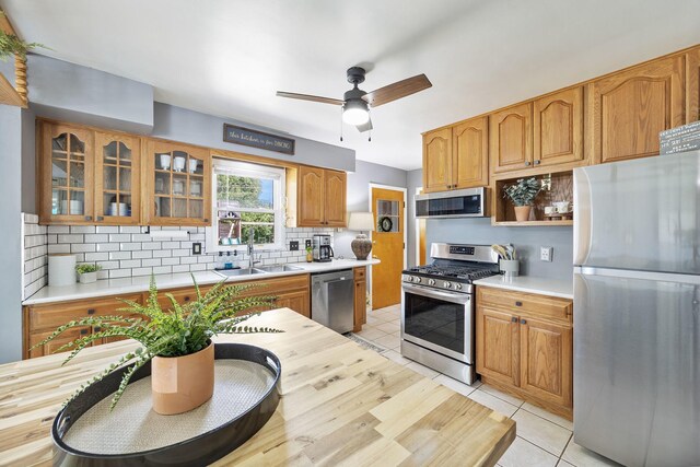 1110 N Main St, Normal, IL 61761 - kitchen with stainless steel appliances, light countertops, backsplash, and glass insert cabinets