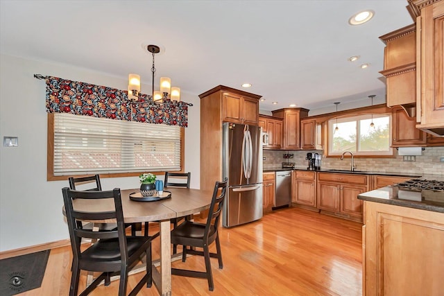 4839 Lamb Dr, Oak Lawn, IL 60453 - kitchen featuring appliances with stainless steel finishes, dark countertops, decorative backsplash, light wood-style flooring, and hanging light fixtures