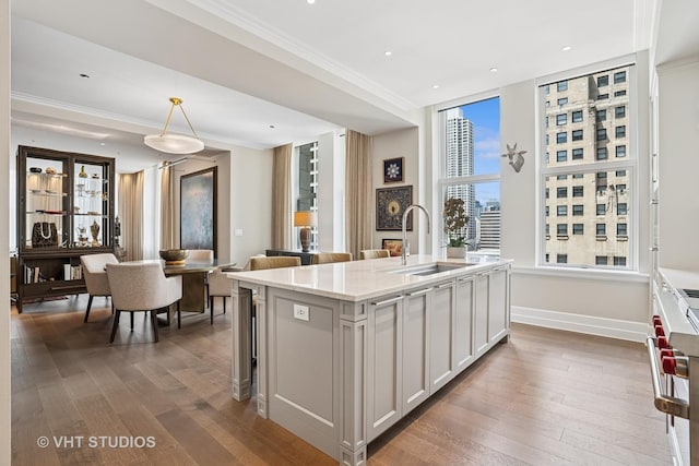 435 N Michigan Ave Unit 1203, Chicago, IL 60611 - kitchen with wood finished floors, white cabinetry, a kitchen island with sink, decorative light fixtures, and range