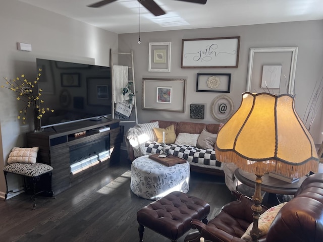 living room featuring ceiling fan, wood finished floors, and a fireplace