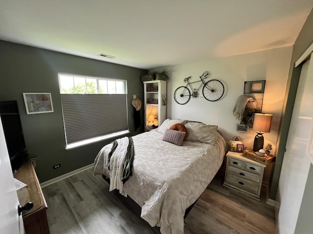bedroom with dark wood finished floors and baseboards