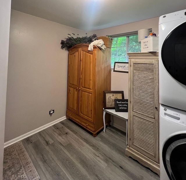 laundry room featuring stacked washing machine and dryer and wood finished floors